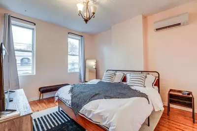 a bedroom with a bed with white sheets and pillows at Comfy Bayonne Townhome about 11 Mi to NYC Attractions in Bayonne