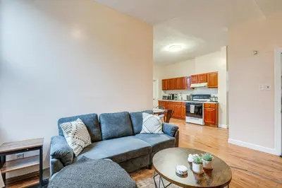 a living room with a blue couch and a table at Comfy Bayonne Townhome about 11 Mi to NYC Attractions in Bayonne
