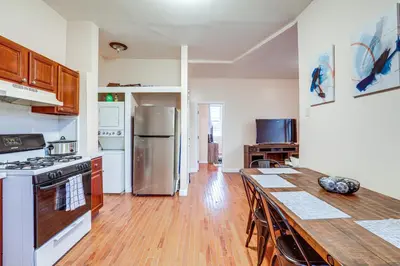 a kitchen with a table and a stove and refrigerator at Comfy Bayonne Townhome about 11 Mi to NYC Attractions in Bayonne