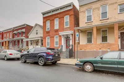 two cars parked on a street in front of houses at Comfy Bayonne Townhome about 11 Mi to NYC Attractions in Bayonne