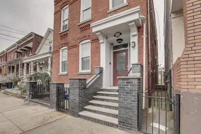 a brick building with a staircase leading to a door at Comfy Bayonne Townhome about 11 Mi to NYC Attractions in Bayonne