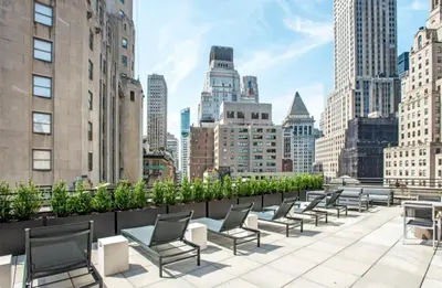 a row of chairs on the roof of a building at FiDi 1br w game room resident-only speakeasy NYC-1346 in New York