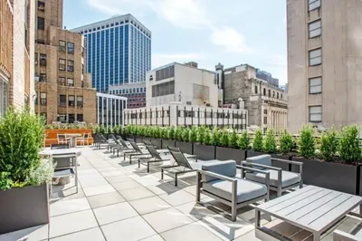 a row of tables and chairs on a rooftop patio with buildings at FiDi 1br w gym doorman lounge nr park NYC-1344 in New York