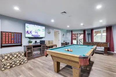 a living room with a pool table and a tv at Cozy cottage in the heart of pocono in Long Pond