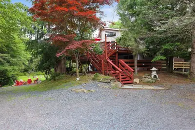 a house with a red stairway in front of it at Cozy cottage in the heart of pocono in Long Pond