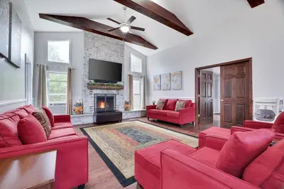 a living room with red furniture and a fireplace at Cozy cottage in the heart of pocono in Long Pond