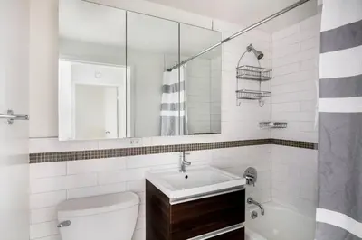 a bathroom with a sink and a toilet and a mirror at Hudson Yards 1br w gym wd nr penn station NYC-1308 in New York
