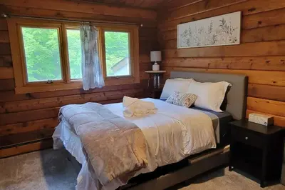 a bedroom with a bed in a log cabin at Comfy Log Cabin Family & Pet Kind by State & Waterparks! in Tobyhanna