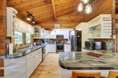 a kitchen with white cabinets and a wooden ceiling at Comfy Log Cabin Family & Pet Kind by State & Waterparks! in Tobyhanna
