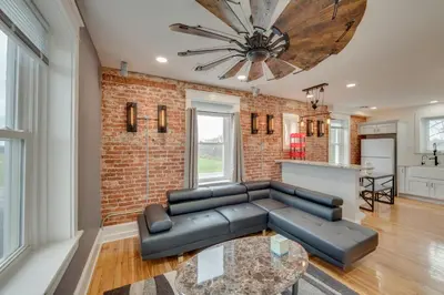a living room with a couch and a brick wall at 15 Mi to Amish Village Cozy Lancaster Apt! in Lancaster