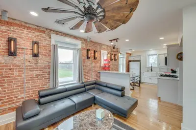 a living room with a couch and a brick wall at 15 Mi to Amish Village Cozy Lancaster Apt! in Lancaster