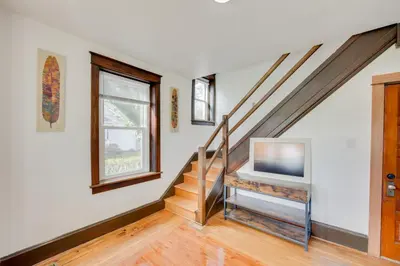 a living room with a staircase and a tv at 15 Mi to Amish Village Cozy Lancaster Apt! in Lancaster