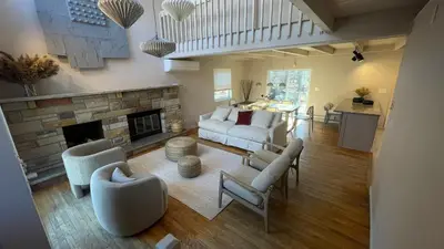 a living room with a white couch and a fireplace at Poconos Modern Chalet I Hot Tub I Home Theater I Fenced Yard I Pet Friendly in East Stroudsburg