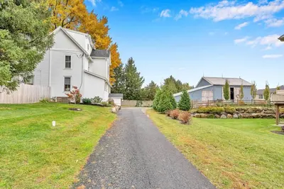 a driveway leading to a white house at Underground Railroad 3 Bedroom Farmhouse in Kennett Square