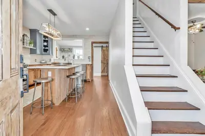 a staircase leading up to a kitchen with a bar at Underground Railroad 3 Bedroom Farmhouse in Kennett Square
