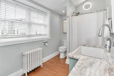 a bathroom with a sink and a toilet and a window at Underground Railroad 3 Bedroom Farmhouse in Kennett Square