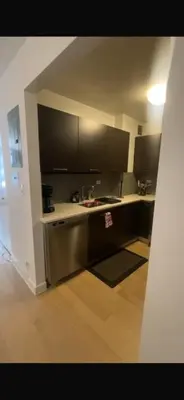 a kitchen with black cabinets and a counter top at Unique Place in midtown NYC in New York