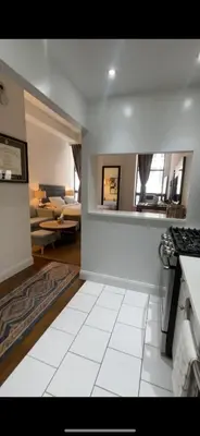 a kitchen with a stove and a living room at Unique Place in midtown NYC in New York