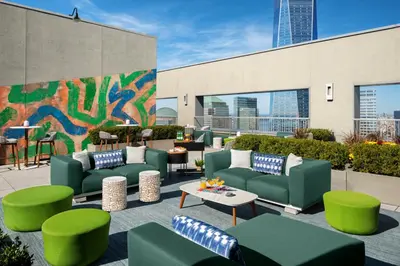 a patio with green couches and tables and a mural at Financial District 1br w WD gym elevator NYC-1368 in New York
