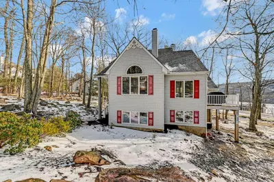 a white house with red shutters in the snow at Poconos Paradise Lakeskihikewater Parkkids in Lake Harmony