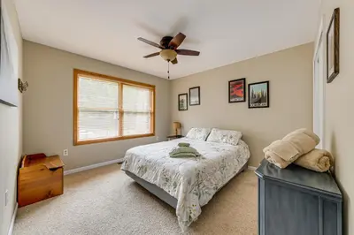 a bedroom with a bed and a ceiling fan at Lakefront Poconos Family Home with Pool Access in Pocono Lake