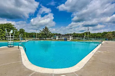a large blue swimming pool in a parking lot at Lakefront Poconos Family Home with Pool Access in Pocono Lake