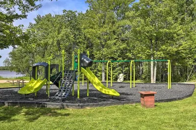 a playground with a slide in a park at Lakefront Poconos Family Home with Pool Access in Pocono Lake