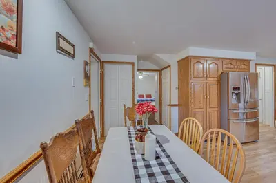 a kitchen with a table with chairs and a refrigerator at Tranquil Mt Pleasant Mills Retreat on 60-Acre Farm in Dalmatia