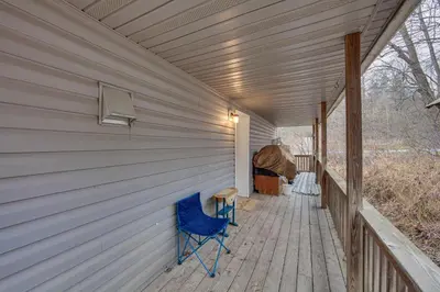 a blue chair sitting on the porch of a house at Tranquil Mt Pleasant Mills Retreat on 60-Acre Farm in Dalmatia