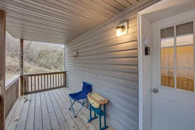 a blue chair sitting on a porch with a door at Tranquil Mt Pleasant Mills Retreat on 60-Acre Farm in Dalmatia