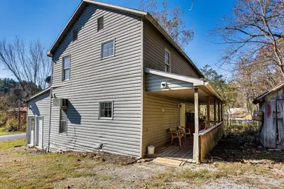 a large white house with a porch and a table at Tranquil Mt Pleasant Mills Retreat on 60-Acre Farm in Dalmatia