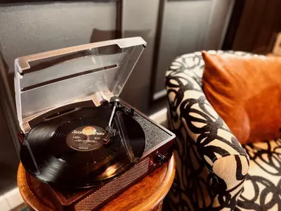 a record player on a table next to a chair at Trio Sonata, 3-Bed Rock n Roll Residence in Northern Liberties in Philadelphia