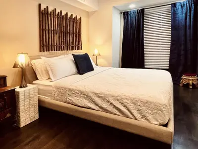 a bedroom with a bed with white sheets and a window at Trio Sonata, 3-Bed Rock n Roll Residence in Northern Liberties in Philadelphia