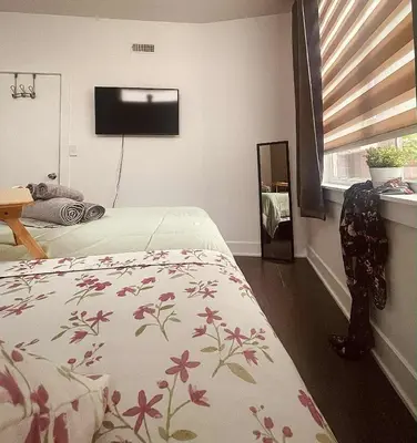 a bedroom with a bed with a flowered blanket at Bright, Cozy Room Near Center City Philadelphia and Museums in Philadelphia