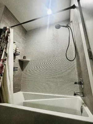 a bathroom with a tub and a shower with a shower head at Bright, Cozy Room Near Center City Philadelphia and Museums in Philadelphia