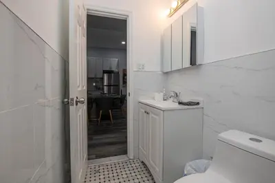 a white bathroom with a toilet and a sink at Spectacular Times Square 5 Bedroom Duplex Oasis in New York