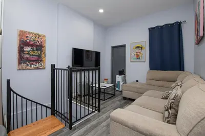 a living room with a couch and a tv at Spectacular Times Square 5 Bedroom Duplex Oasis in New York