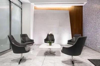 a waiting room with black chairs and a table at Financial District studio w gym doorman NYC-1289 in New York