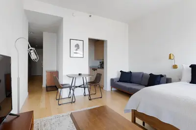 a bedroom and living room with a bed and a table at Financial District studio w gym doorman NYC-1289 in New York
