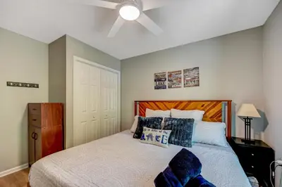 a bedroom with a bed with a ceiling fan at 1 Mi to Beach Pocono Lake Chalet with Decks in Pocono Lake