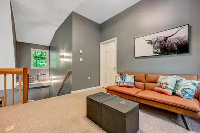 a living room with a couch and a cow on the wall at 1 Mi to Beach Pocono Lake Chalet with Decks in Pocono Lake