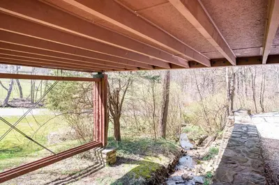 an outside window of a house with a view of the woods at Mid Century Modern Getaway with outdoor Hot Tub in Wernersville