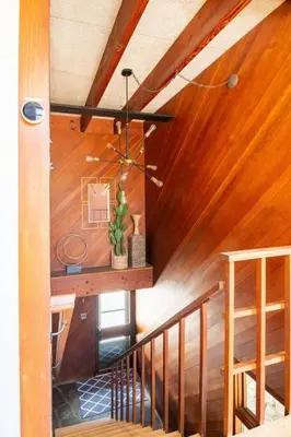 a staircase in a room with wooden walls and a ceiling at Mid Century Modern Getaway with outdoor Hot Tub in Wernersville