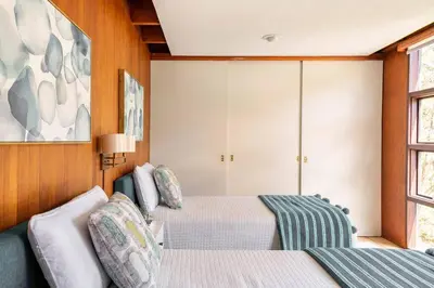a bedroom with two beds and a couch at Mid Century Modern Getaway with outdoor Hot Tub in Wernersville