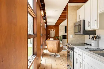 a kitchen with a chair in the middle of it at Mid Century Modern Getaway with outdoor Hot Tub in Wernersville