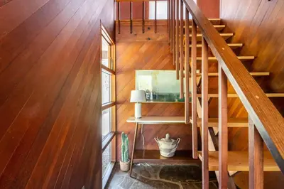 a wooden staircase in a room with wooden walls and wooden floors at Mid Century Modern Getaway with outdoor Hot Tub in Wernersville