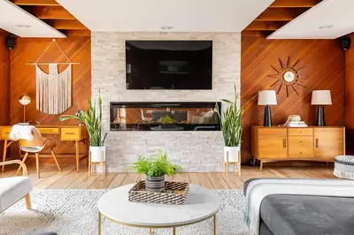 a living room with a fireplace with a tv at Mid Century Modern Getaway with outdoor Hot Tub in Wernersville