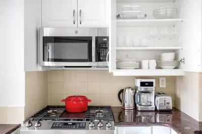 a kitchen with a stove top oven with a microwave at Kips Bay 1BR w Doorman Elevator Gym NYC-478 in New York