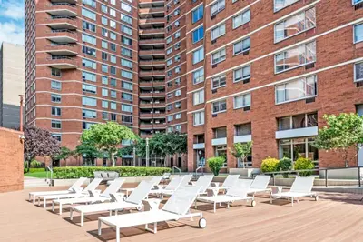 a row of white lounge chairs in front of a building at Kips Bay 1BR w Doorman Elevator Gym NYC-478 in New York