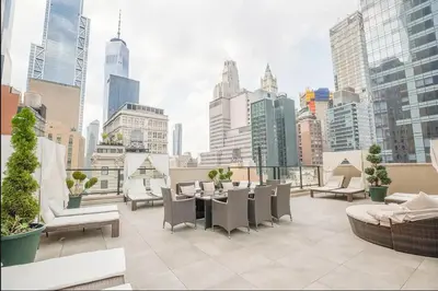 a rooftop patio with a view of a city at Luxury 2BD nr Wall St Gym Rooftop w/d in New York